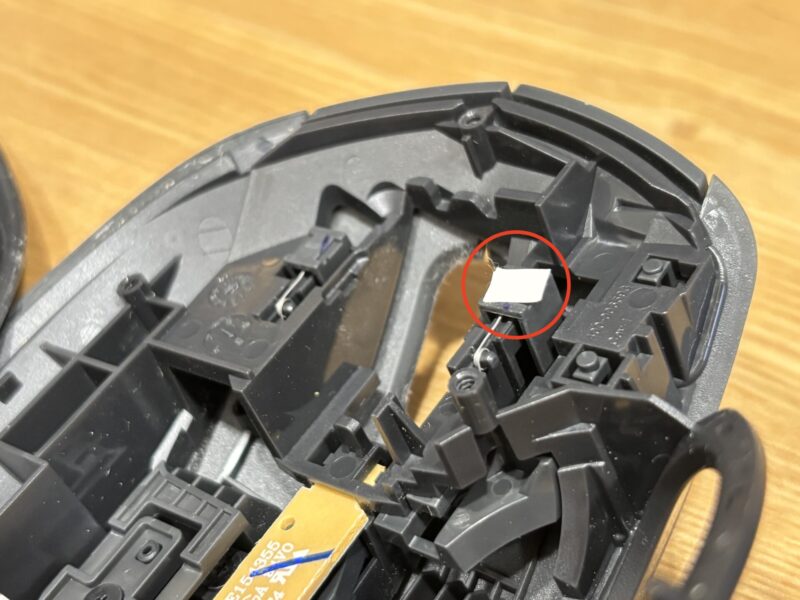 左クリックボタンの裏側にマスキングテープを小さく切ったものを貼っている写真